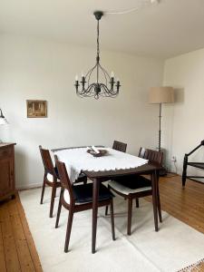 a dining room table with chairs and a chandelier at NAO Eifelhaus von 1875 mit Garten in Üxheim
