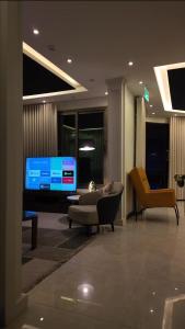 a living room with a couch and a television at شاليهات بتلات الورد in Taif