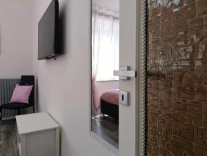 a room with a door with a mirror and a bed at La casa di Armida in Radicofani