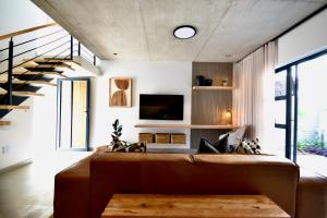 a living room with a brown couch and a staircase at Rustic Hills 39 in Swakopmund