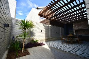 a patio with a table and a wooden pergola at Rustic Hills 39 in Swakopmund