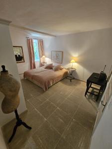 a bedroom with a bed and a table and a window at La Ribaude in Crestet +21 photos