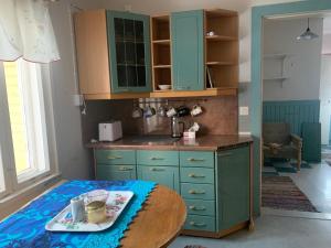 a kitchen with green cabinets and a table in it at Koskelo in Kiuruvesi