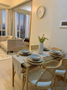 a dining room table with chairs and a clock on the wall at The SB Residences Luxury Executive Studio in Iloilo City