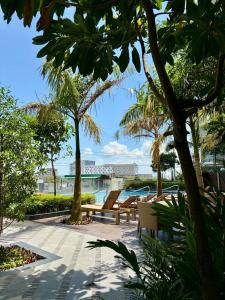 a patio with benches and palm trees in a resort at The SB Residences Luxury Executive Studio in Iloilo City