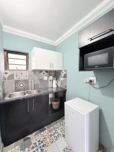 a kitchen with a sink and a microwave at The Hide on 37 Flamingo in East London