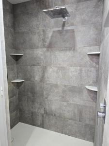 a bathroom with a shower with a stone wall at Southbay Alquiler in San Fernando +19 photos