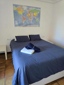 a blue bed with a hat and a map on the wall at Southbay Alquiler in San Fernando