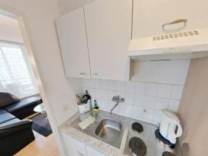 a kitchen with white cabinets and a sink at Appartement Sandra im Bayerischen Wald mit Pool in Freyung