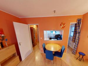 a dining room with orange walls and a table and chairs at Appartement Sandra im Bayerischen Wald mit Pool in Freyung
