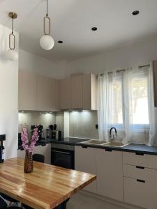 a kitchen with a wooden table and a vase of flowers at Vista Mare Maisonette in Ipsos