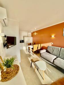 a living room with a couch and a table at Appartement vue mer Domaine Les Restanques Grimaud in Grimaud