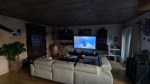 a living room with a white couch and a flat screen tv at Chez igor in Pétange