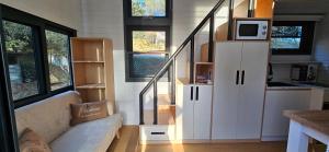 a living room with a couch in a tiny house at Tiny house avec jacuzzi in Cadenet +5 photos