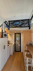 a small kitchen with a counter and a table in a caravan at Tiny house avec jacuzzi in Cadenet