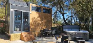 a tiny house with a grill and a table and chairs at Tiny house avec jacuzzi in Cadenet