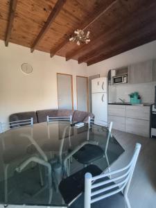 a living room with a glass table and chairs at ÁMBAR DEPARTAMENT boutique in Monte Grande