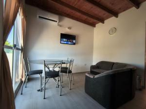 a living room with a table and chairs and a couch at ÁMBAR DEPARTAMENT boutique in Monte Grande