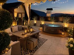 a backyard patio with a hot tub and a table at Holiday house "Mimoza" 2 massage pools in Otočac