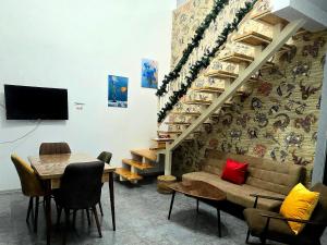 a room with a table and a couch and a staircase at Chalet Weekend in Borjomi