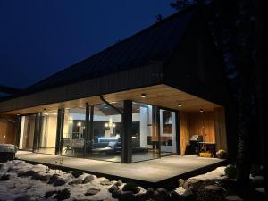 a large glass house with a living room at night at Chalet Beyond in Veľká Lomnica