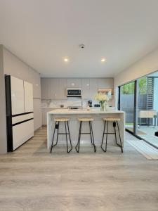 a kitchen with a large island with two stools at Casa Madrisqui Heated Pool Oasis 12 Guests Midway Keys & Miami in Homestead