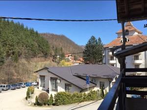 a house on a street with cars parked on the road at Apartman Smilic Lukovska banja in Lukovo