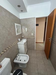 a bathroom with a white toilet and a sink at Zárate Temporarios in Zárate