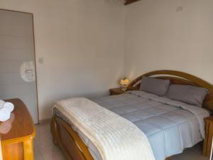 a bedroom with a bed with a wooden frame and a table at ÁMBAR DEPARTAMENT boutique in Monte Grande