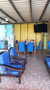 a room with chairs and a table and a flat screen tv at Arrullos del Mar in Zorritos