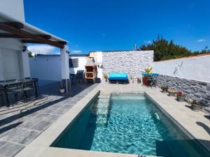 a swimming pool on a patio with a table and chairs at La magia del sur 2 in Cádiz
