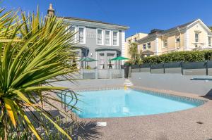 a swimming pool in front of a house at The Devon Court in Torquay