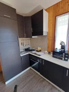 a kitchen with black cabinets and a white counter top at Eva House 2 in Fanano +2 photos