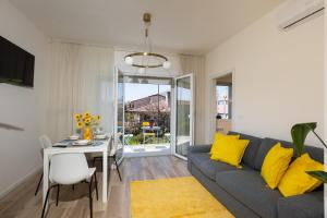a living room with a couch and a table with yellow pillows at Gradisca Go Home 2 in Gradisca dʼIsonzo