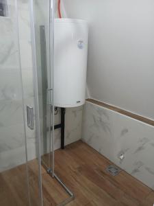 a small white refrigerator in a corner of a bathroom at Vikendica Bogdanović in Nova Varoš +20 photos
