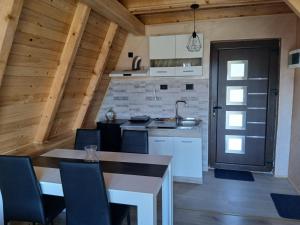a kitchen and dining room with a table and chairs at Vikendica Bogdanović in Nova Varoš
