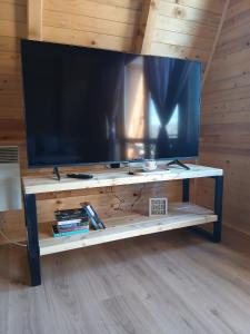 a large tv on a wooden table with a shelf at Vikendica Bogdanović in Nova Varoš