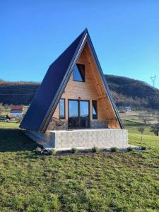 a small house with a pitched roof on a field at Vikendica Bogdanović in Nova Varoš