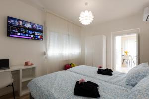 a bedroom with two beds and a tv on the wall at Gradisca Go Home 2 in Gradisca dʼIsonzo