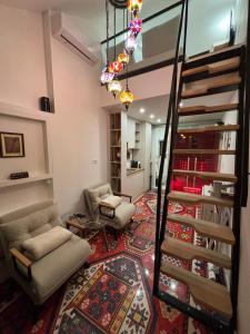 a living room with two chairs and a spiral staircase at EPICENTAR Luxury Jacuzzi & Sauna Apartment in Baščaršija - Private Spa Experience in Sarajevo