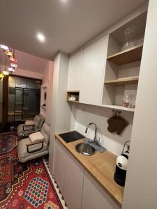a small kitchen with a sink and a living room at EPICENTAR Luxury Jacuzzi & Sauna Apartment in Baščaršija - Private Spa Experience in Sarajevo