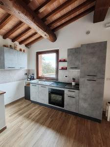 a large kitchen with stainless steel appliances and wood floors at La Capanna in Radicofani