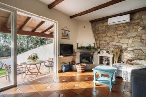 a living room with a fireplace and a stone wall at Casa Costaneira in Boiro