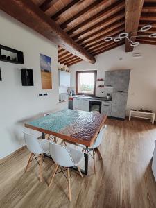 a dining room with a table and chairs and a kitchen at La Capanna in Radicofani