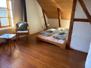 a bedroom with a bed and a chair and a table at Deichliebe 290 Ökologisches Ferienhaus Stöckte in Winsen
