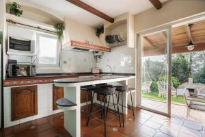 a kitchen with a counter and stools in it at Casa Costaneira in Boiro