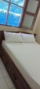 a bed with two pillows in a room with a window at Perfect Backpacker Spot in Shimoni