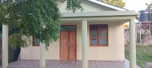 a small white house with a wooden door at Perfect Backpacker Spot in Shimoni