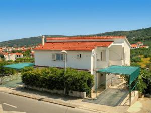 a white house with a red roof and a street at Apartments Boa in Slatine