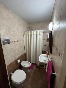 a small bathroom with a toilet and a sink at Casa Mitre in Luján